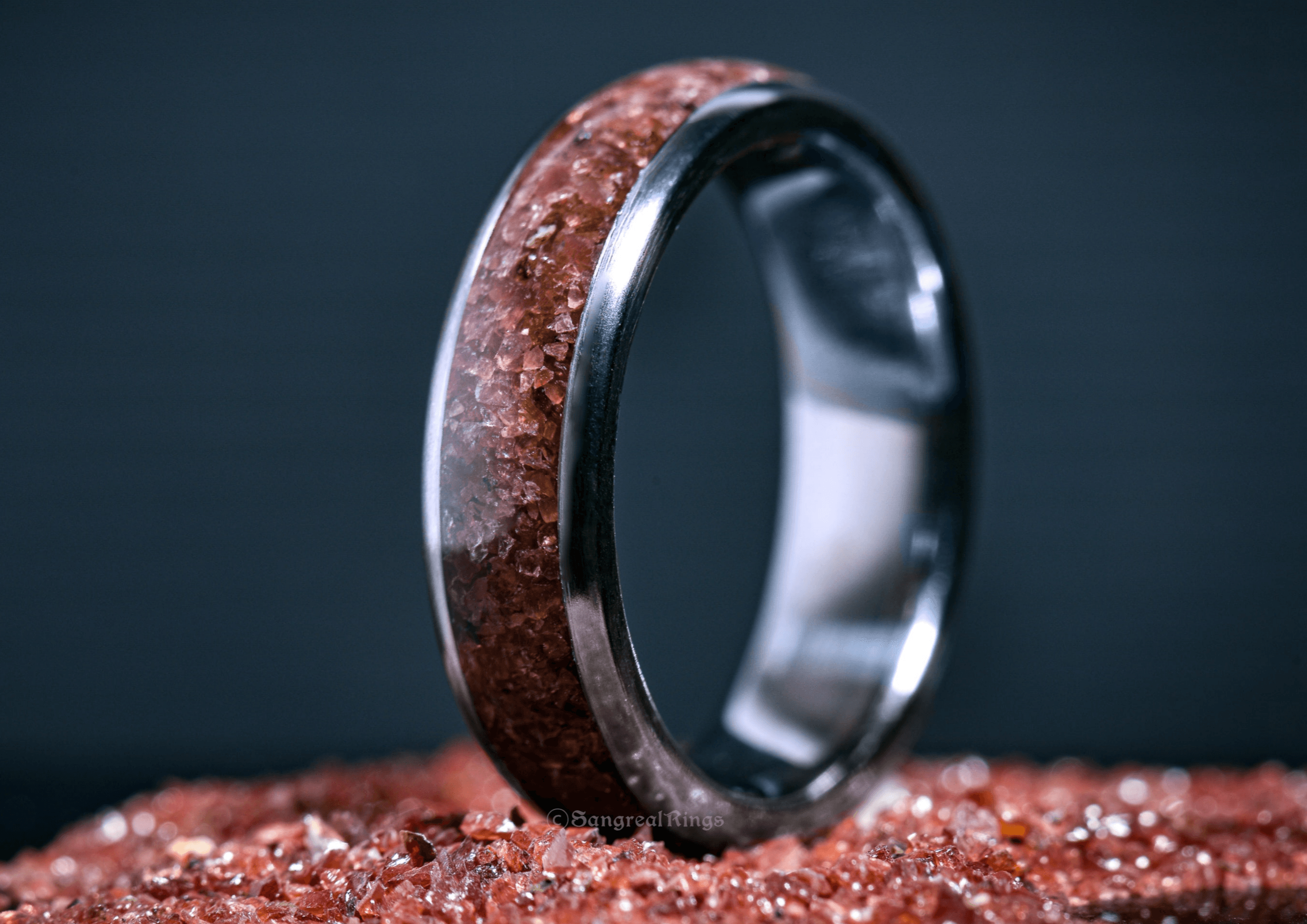 Custom garnet titanium ring from Sangreal Rings with embedded red garnet crystals in a polished titanium band