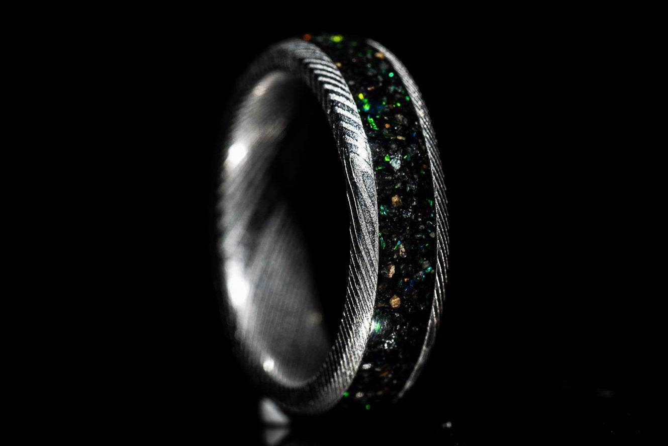 Sangreal Rings custom Damascus steel sand inlay wedding band featuring black green sand inlay and textured Damascus pattern