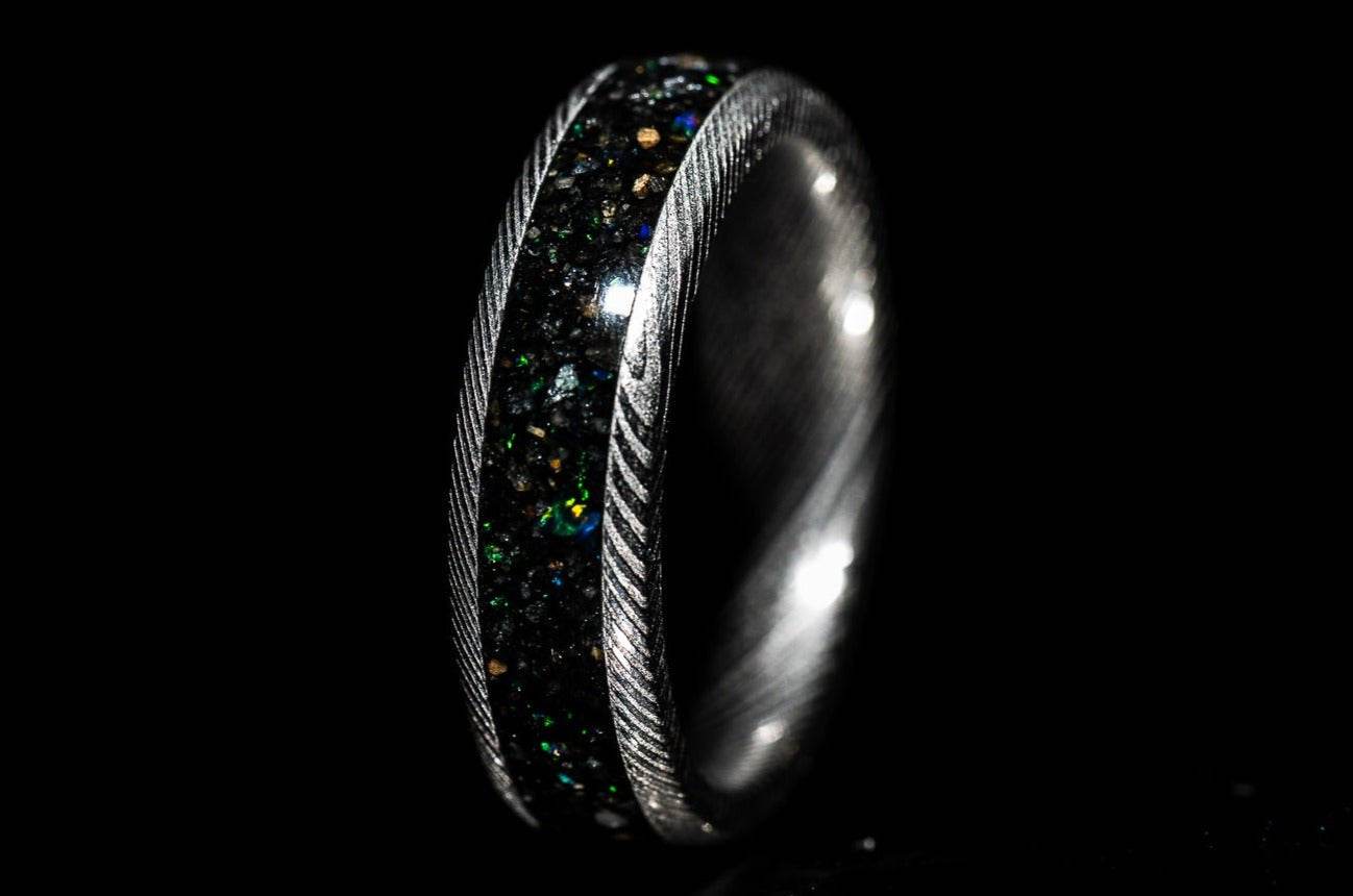 Sangreal Rings custom Damascus steel sand inlay wedding band featuring black green iridescent sand and twisted Damascus edges