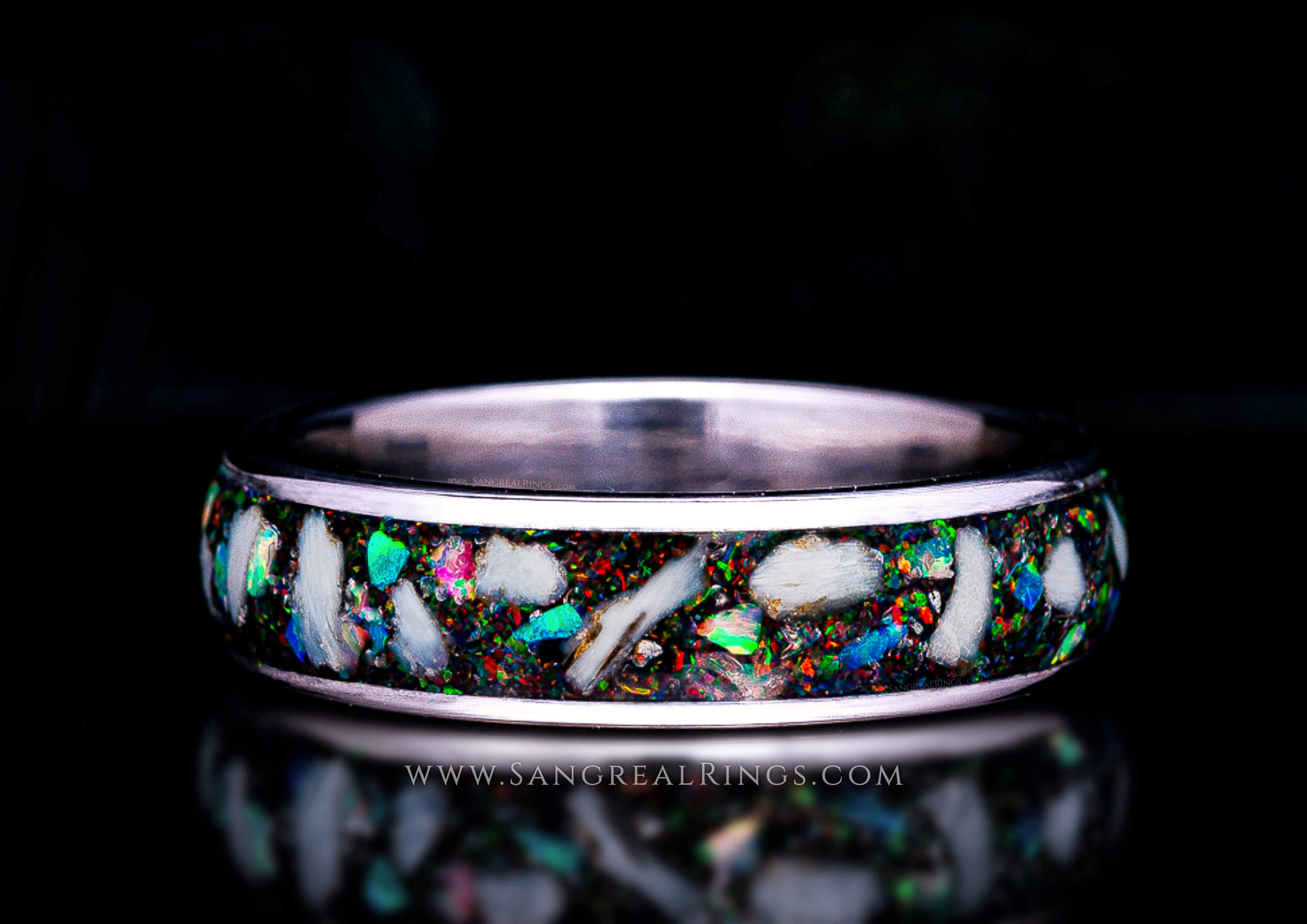 Custom Silver Titanium Memorial ring with embedded keepsake cremation Ashes and multicolored opal inlay on a black background, handcrafted by Sangreal Rings.