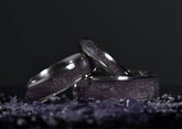 Set of amethyst titanium ring crystal rings by Sangreal Rings with purple stone inlay on dark background