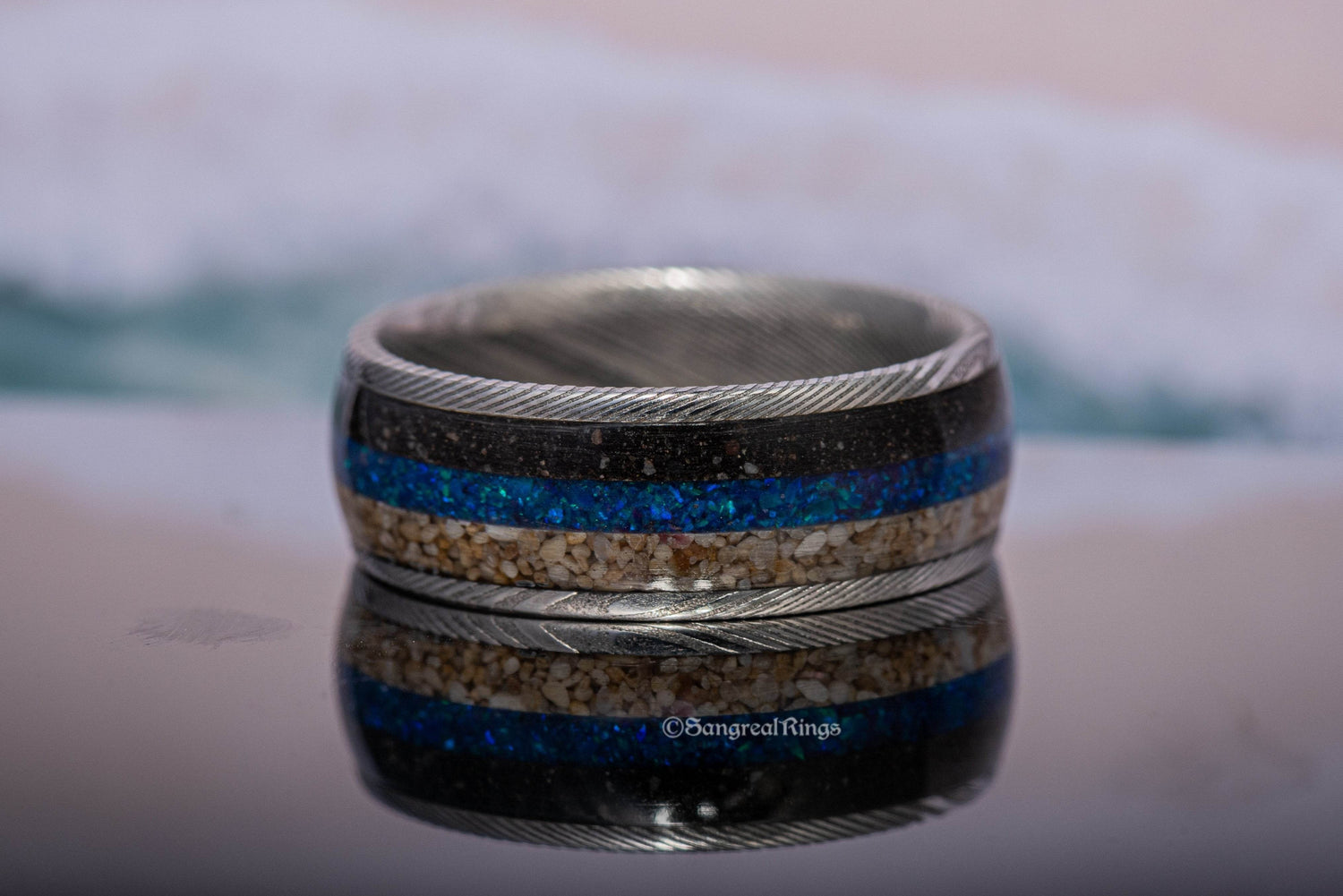 Sangreal Rings Damascus steel sand ring with blue opal and sand inlay and braided steel edges
