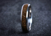 Sangreal Rings titanium sand ring with brown sand inlay and polished metal edges on dark background