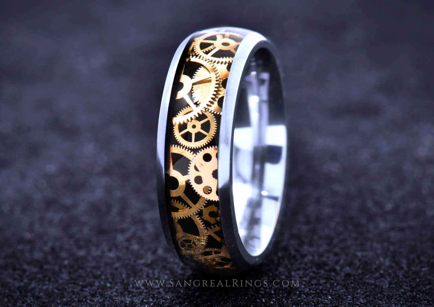 Sangrealrings titanium steampunk ring with gold gear inlay and polished silver edges on black backdrop