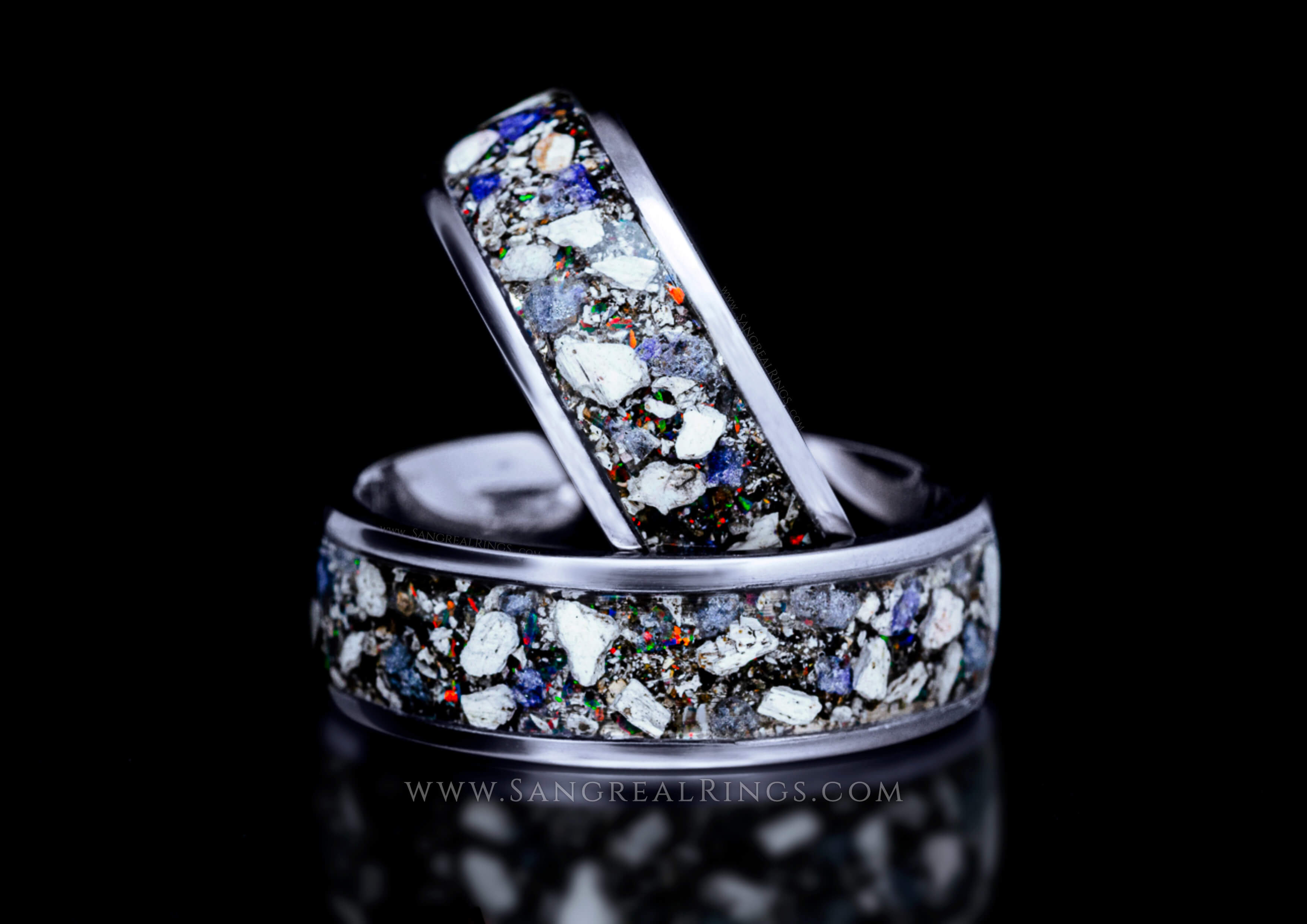 Matching Titanium memorial ring bands ring with multicolored opal and blue sapphire gemstones on a black background
