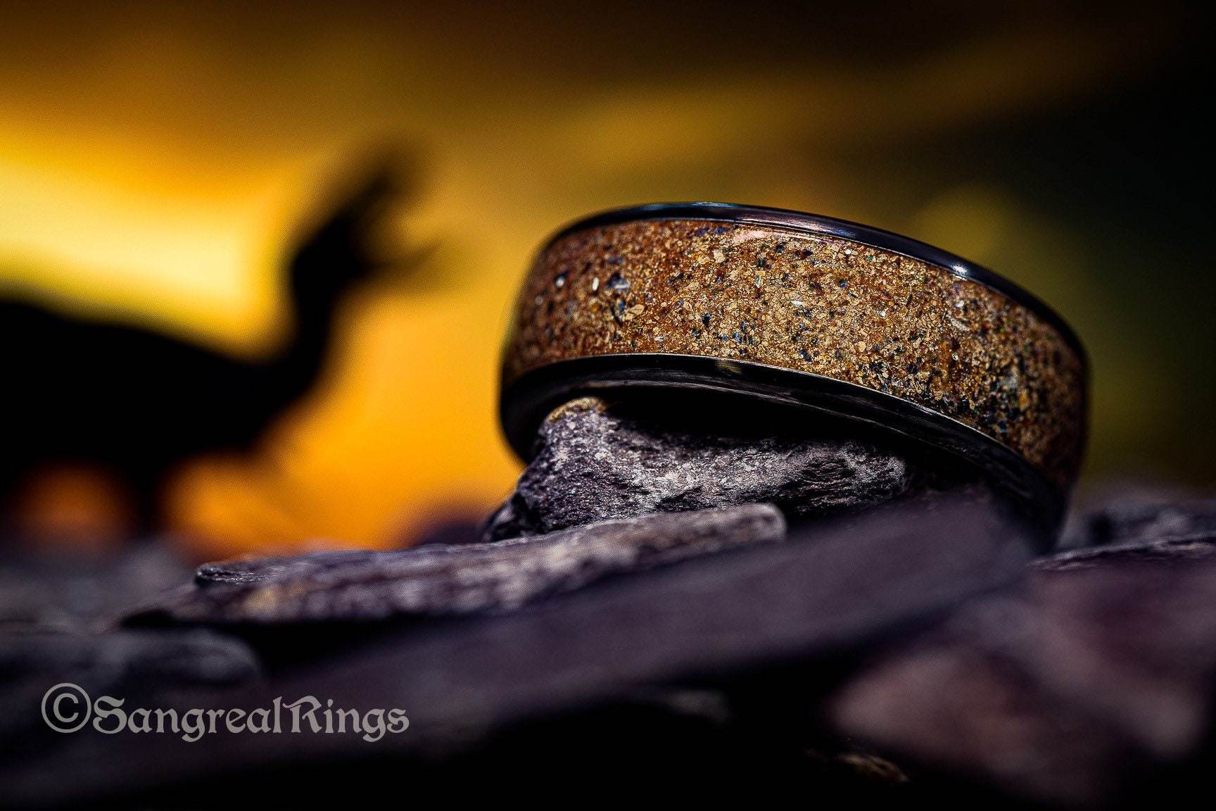 Sangrealrings opal dinosaur bone ring with earthy tones displayed on textured stones