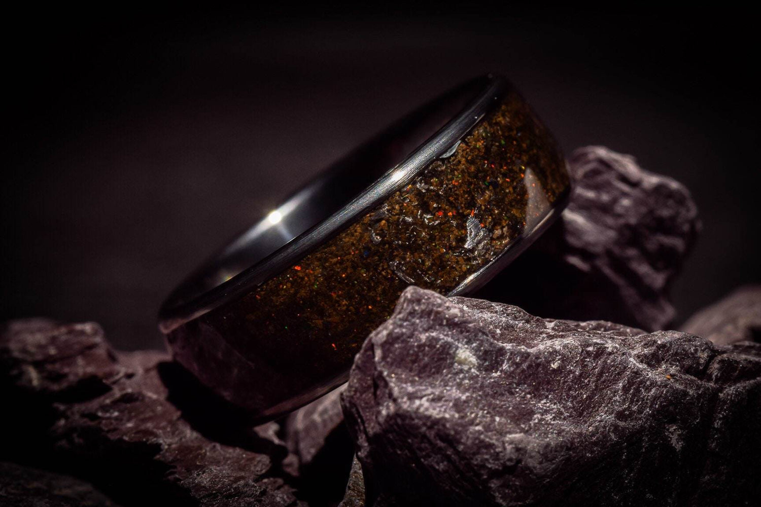 Sleek opal megalodon tooth meteorite ring by Sangrealrings displayed on dark textured stones