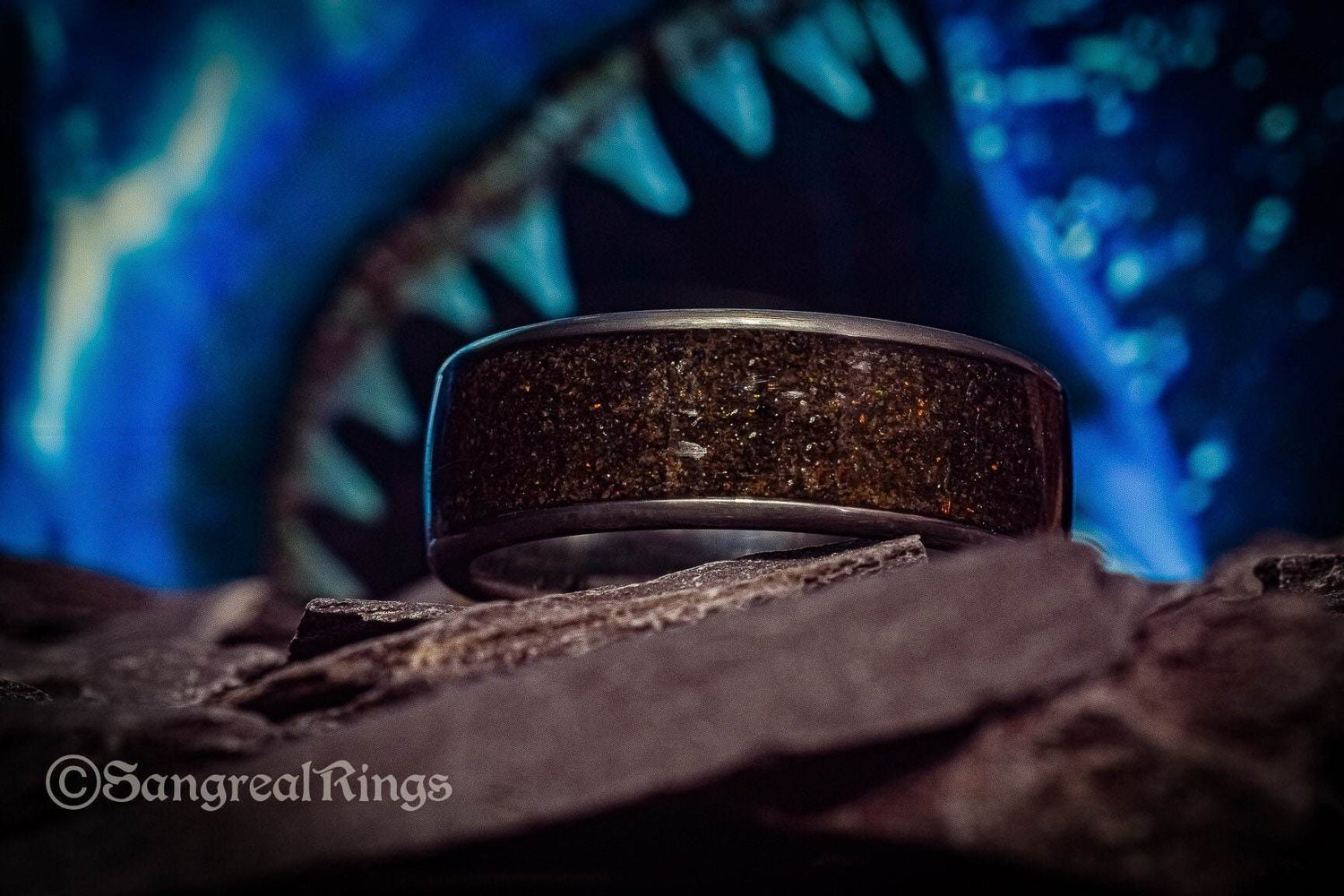 Opal megalodon tooth meteorite ring by Sangrealrings displayed on rock with shark teeth background