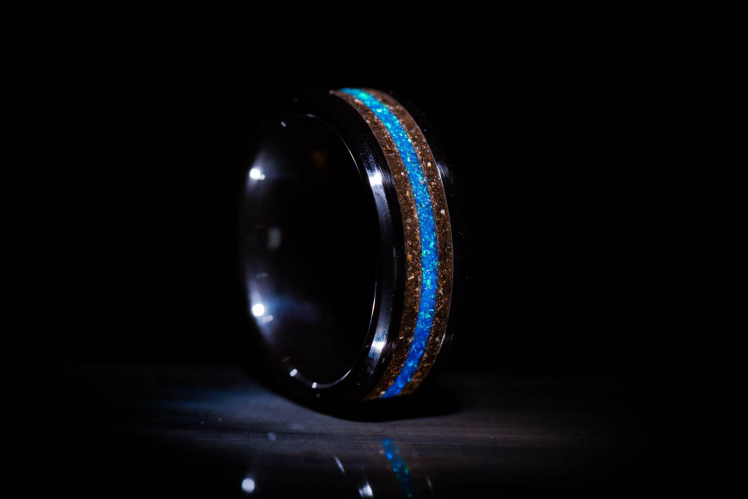 Sangreal Rings black ceramic sand ring with blue glowing inlay detail on black background