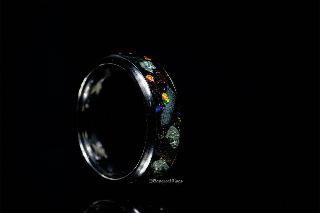 Sangrealrings titanium jurassic ring with colorful embedded stone design on black background