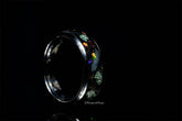 Sangrealrings titanium jurassic ring with colorful embedded stone design on black background