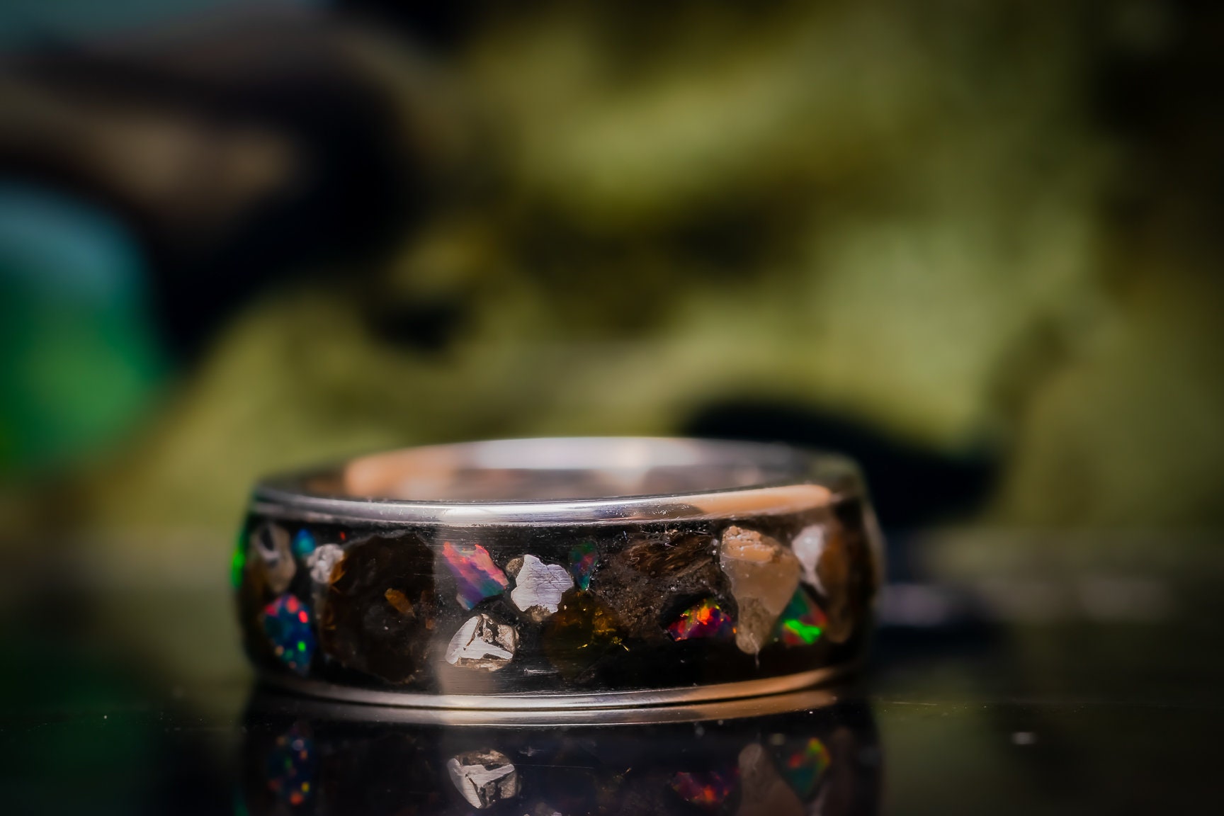 Unique lost world ring with multicolored stone inlays and a polished dark band by Sangrealrings
