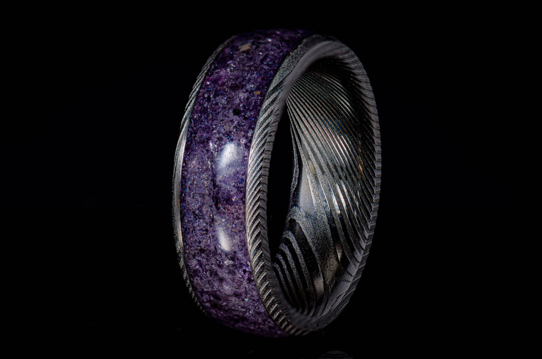 Damascus steel amethyst ring with intricate metal pattern and polished purple amethyst inlay