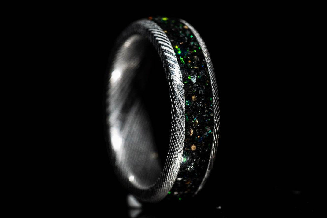 Sangreal Rings custom Damascus steel sand inlay wedding band featuring black green sand inlay and textured Damascus pattern