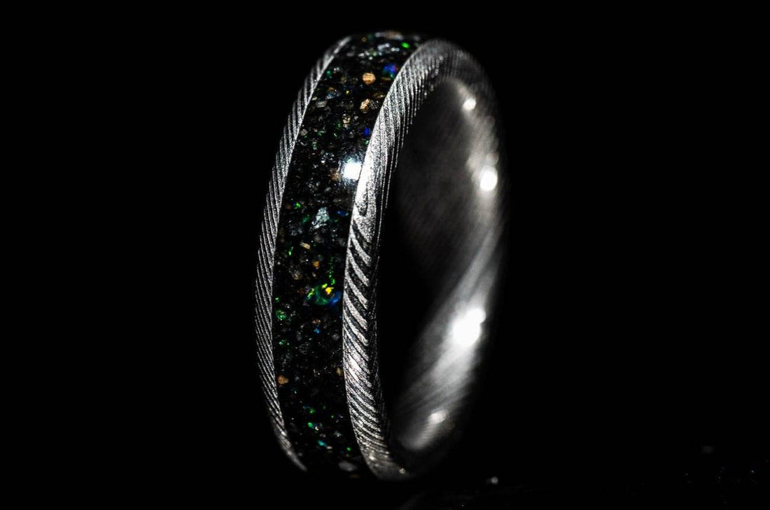 Sangreal Rings custom Damascus steel sand inlay wedding band featuring black green iridescent sand and twisted Damascus edges