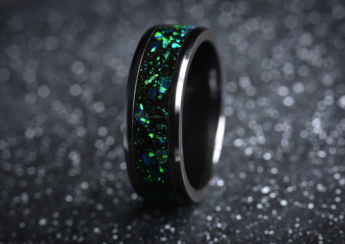 Sleek onyx and green opal ring with shimmering inlay by Sangreal Rings on black glittery surface