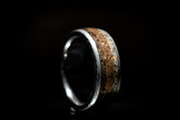 Sangreal Rings Damascus steel sand ring with textured sand inlay on a dark background