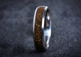 Sangreal Rings titanium sand ring with brown sand inlay and polished metal edges on dark background