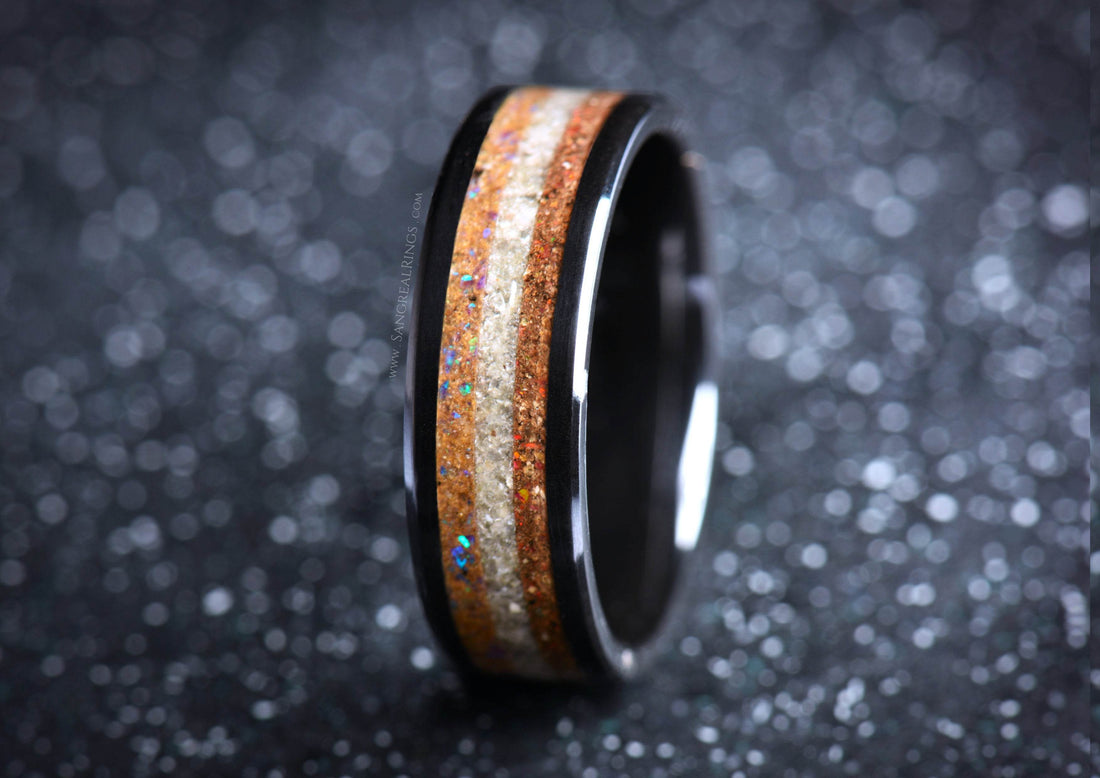 Sangreal Rings black ceramic sand ring with wood and sand inlay on dark bokeh background