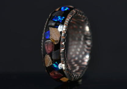 superconductor ring with raptor fossil blue opal and garnet shards made by sangrealrings on a dark background