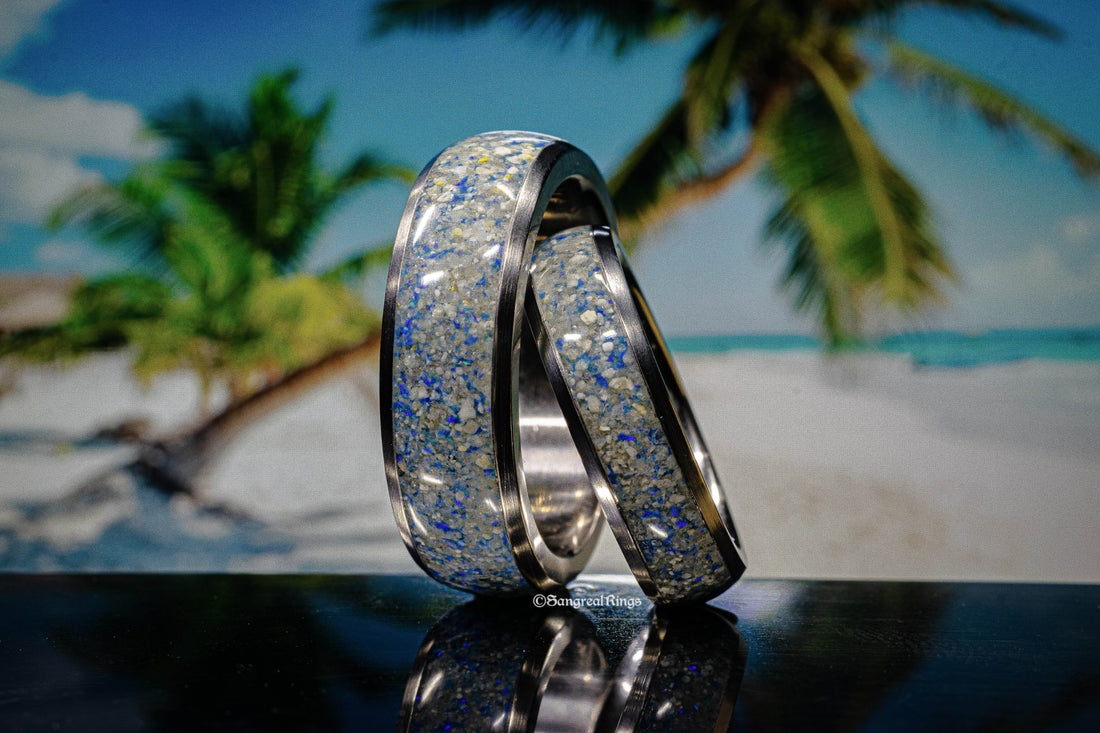 Sangreal Rings titanium sand ring with shimmering blue and silver sand inlay on tropical beach background